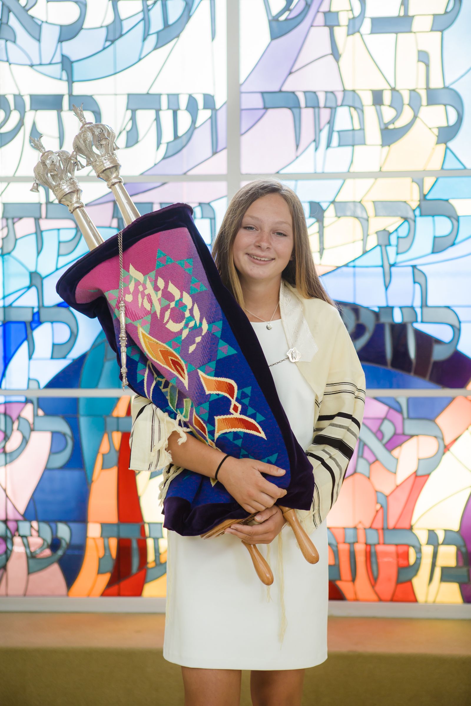"A moment of faith and tradition! A young girl holds the Torah with pride during her Mitzvah ceremony, embracing her heritage and spiritual journey. A beautiful milestone captured in time. #MitzvahPhotography #BatMitzvah #TorahReading #JewishTradition #FaithAndHeritage #TimelessMoments
