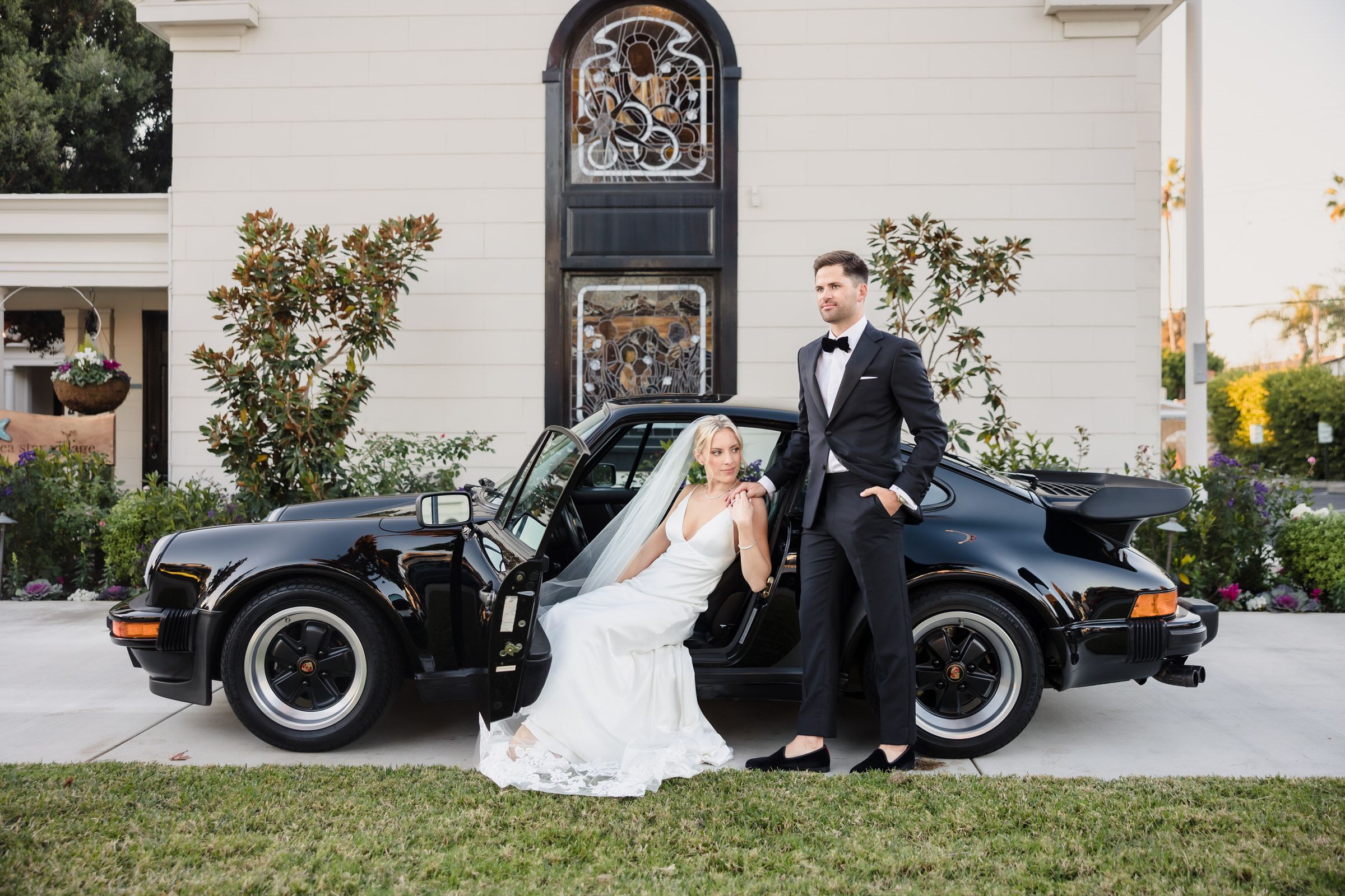 Timeless elegance meets luxury! A stunning wedding couple poses with a sleek Porsche, capturing sophistication, style, and romance. Expertly photographed by VOX Photography for a truly unforgettable moment. #VOXPhotography #WeddingPhotographer #LuxuryWedding #ElegantCouple #PorscheWedding #TimelessRomance